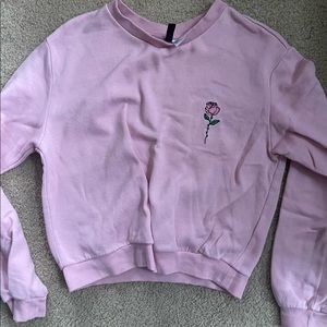 Pretty pink sweatshirt with small rose embroidered on left.